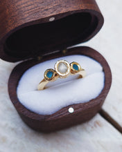 Load image into Gallery viewer, Side view of a custom ROCK engagement ring that features a raw diamond and two blue sea glass. The knife edge band adds an elegance to the rock textured bezels and raw treasures.