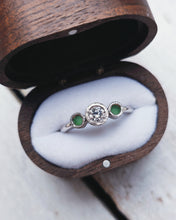 Load image into Gallery viewer, Side view of a custom trilogy bezel set engagement ring that features an ocean diamond in the middle with sea glass flanking it. The hammer textured bezels with the smooth band adds an rustic elegance to the design.
