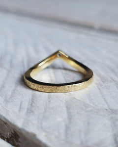 An 18ct gold curved wedding ring that is handmade in Cornwall to seemlessly fit around an engagement ring.