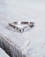 Load image into Gallery viewer, Wedding ring that has a V shaped chevron that is designed to pair with an engagement ring. It has five ocean diamonds that are flush set in the 18ct white gold band with a hammered finish.
