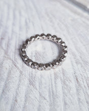 Load image into Gallery viewer, Front view of the wedding ring, showing the rock textured bezel settings that go the whole way around the rustic looking 18ct white gold band. It has an organic and earthy, yet elegant look.
