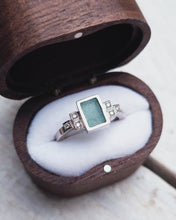 Load image into Gallery viewer, Side view of an art deco inspired sea glass and ocean diamond engagement ring. There is bezel set rectangle sea glass in the middle, with two square bezels either side, then 1 more square bezel either side. 
