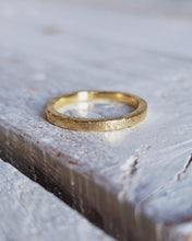 Load image into Gallery viewer, A close up that shows the lovely handmade texture on this plain wedding band which is a square shape and created from 18ct yellow gold.
