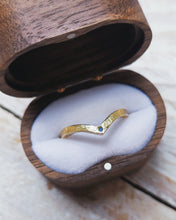 Load image into Gallery viewer, An 18ct yellow gold wedding ring that has a textured finish and blue sea glass set within the point of the wishbone.
