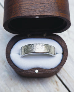 This wedding ring has been handmade from thick sterling silver with a handforged texture on it.