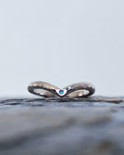 Load image into Gallery viewer, Close up showing flush set tealquoise sea glass in a wishbone style wedding ring that is handmade in 18ct white gold with a hammered finish.
