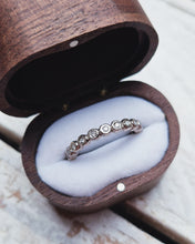 Load image into Gallery viewer, Rustic rock textured wedding ring that is custom made. It has a full band of bezels that have premium quality ocean diamonds set within them. 
