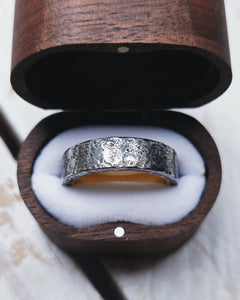 The outside of this wedding ring is dark grey oxidised silver with an 18ct yellow gold inlay. It has a rustic and strong look.