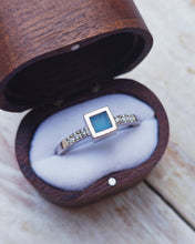 Load image into Gallery viewer, Close-up of a custom ELYSIUM engagement ring showing blue sea glass with a total of six pave set ocean diamonds in 18ct white gold.
