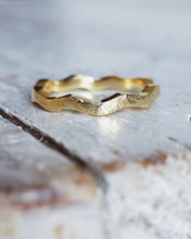 Load image into Gallery viewer, An 18ct yellow gold wedding ring that features a continuous set of waves flowing around the entire ring with a textured unique finish.
