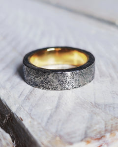Two tone mens wedding ring with oxidised silver on the outside and lustrous highly polished 18ct yellow gold on the inside.
