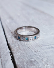 Load image into Gallery viewer, Front view of a handmade sea glass and ocean diamond eternity ring showing flush set stones.

